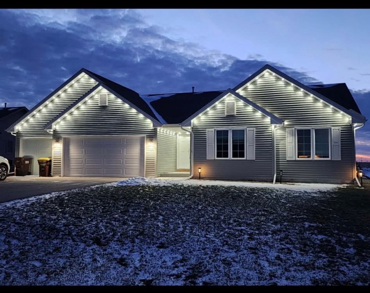 Residential home at night with crisp white roofline holiday lighting