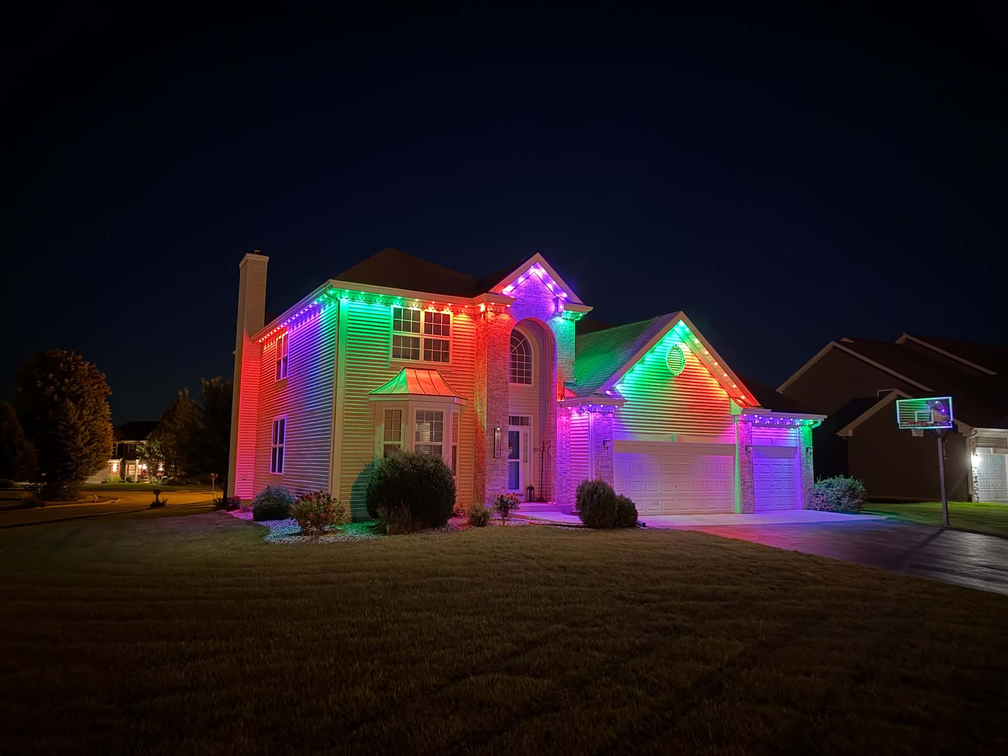 att.bsEgdk5T1uTjE2nRLankSQRGh8CoRlT8eRpM4FIY-ls Home with colorful custom Christmas lights at night